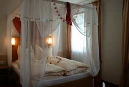 Weisses Himmelbett, dekoriert mit Rosenblättern