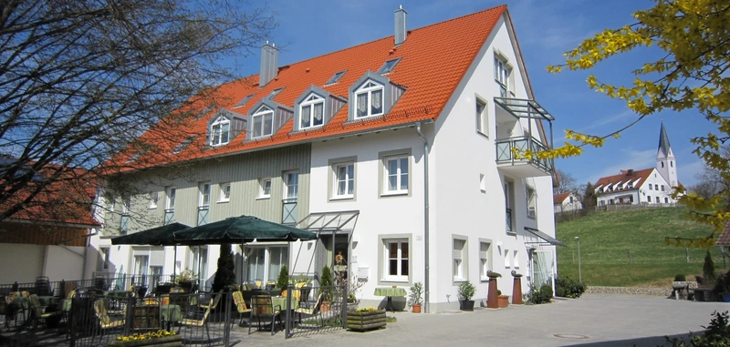 Blick auf das Gasthaus mit sommerlicher Frühstücksterrasse